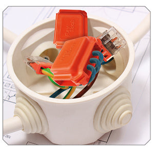 Two orange enclosures protecting completed wire connections inside a round junction box